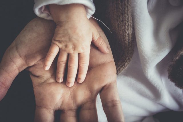 La main d'un enfant dans la main d'un parent